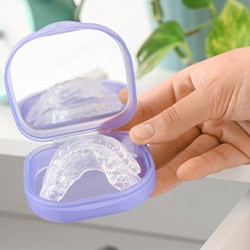 Hand holding case containing clear nightguard