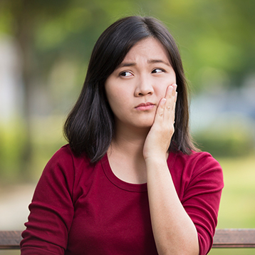 Woman in pain holding jaw