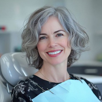 Beautiful, mature woman smiling in dental treatment chair