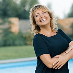 An older woman smiling next to a pool