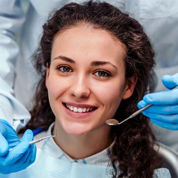 Woman preventing dental emergencies in Wylie by completing dental checkups