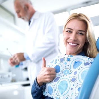 woman giving thumbs up in dental chair