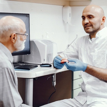 Dentist and patient discussing patient’s candidacy for implant dentures