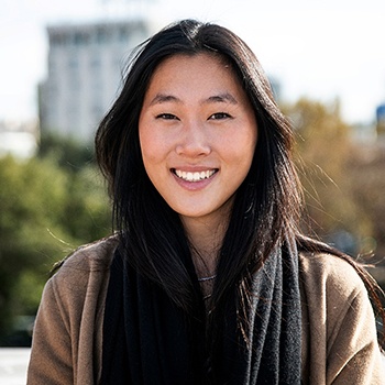 a smiling woman standing outside