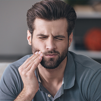 Man holding jaw in pain