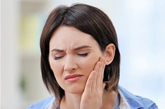 Woman in pain holding jaw