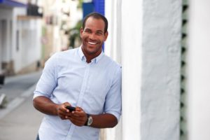 person smiling and leaning against a building