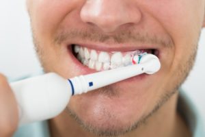 man brushing his teeth 