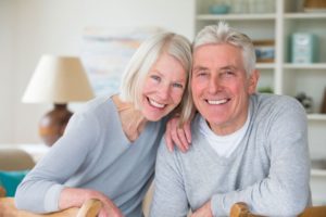 elderly couple smiling with dental implants 