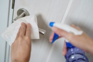 dentist sanitizing door handles in their office