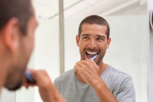 man brushing his teeth