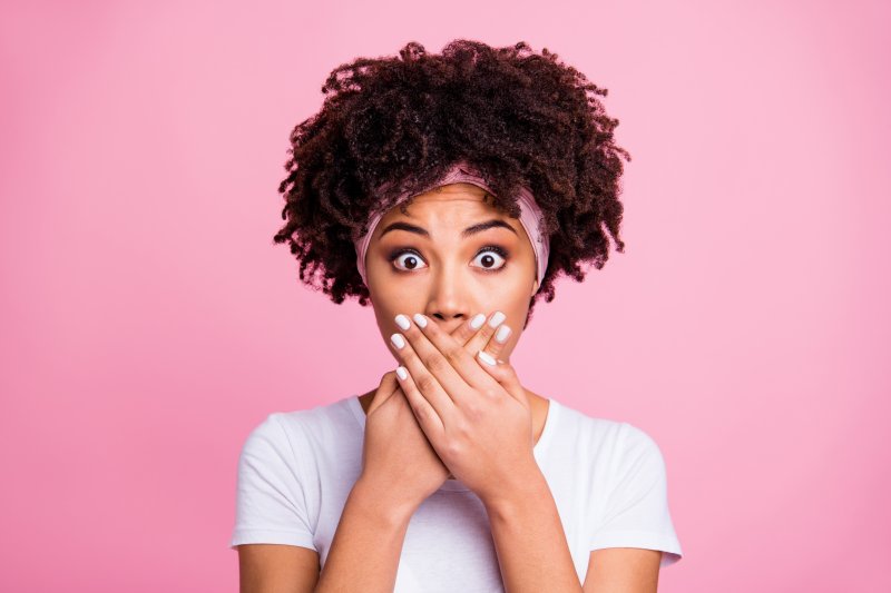 Closeup of woman covering her mouth in shock