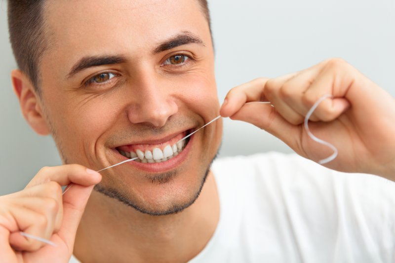 Portrait of a man flossing his teeth