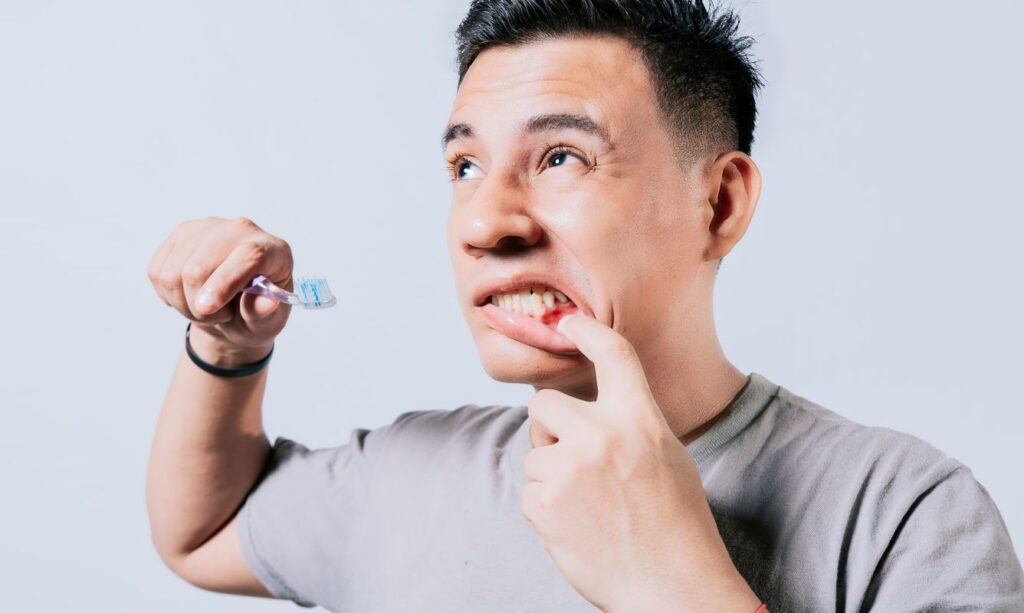 A man with red, swollen gums brushing his teeth.