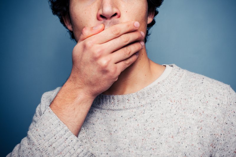 A shocked young man covering his mouth with his hand